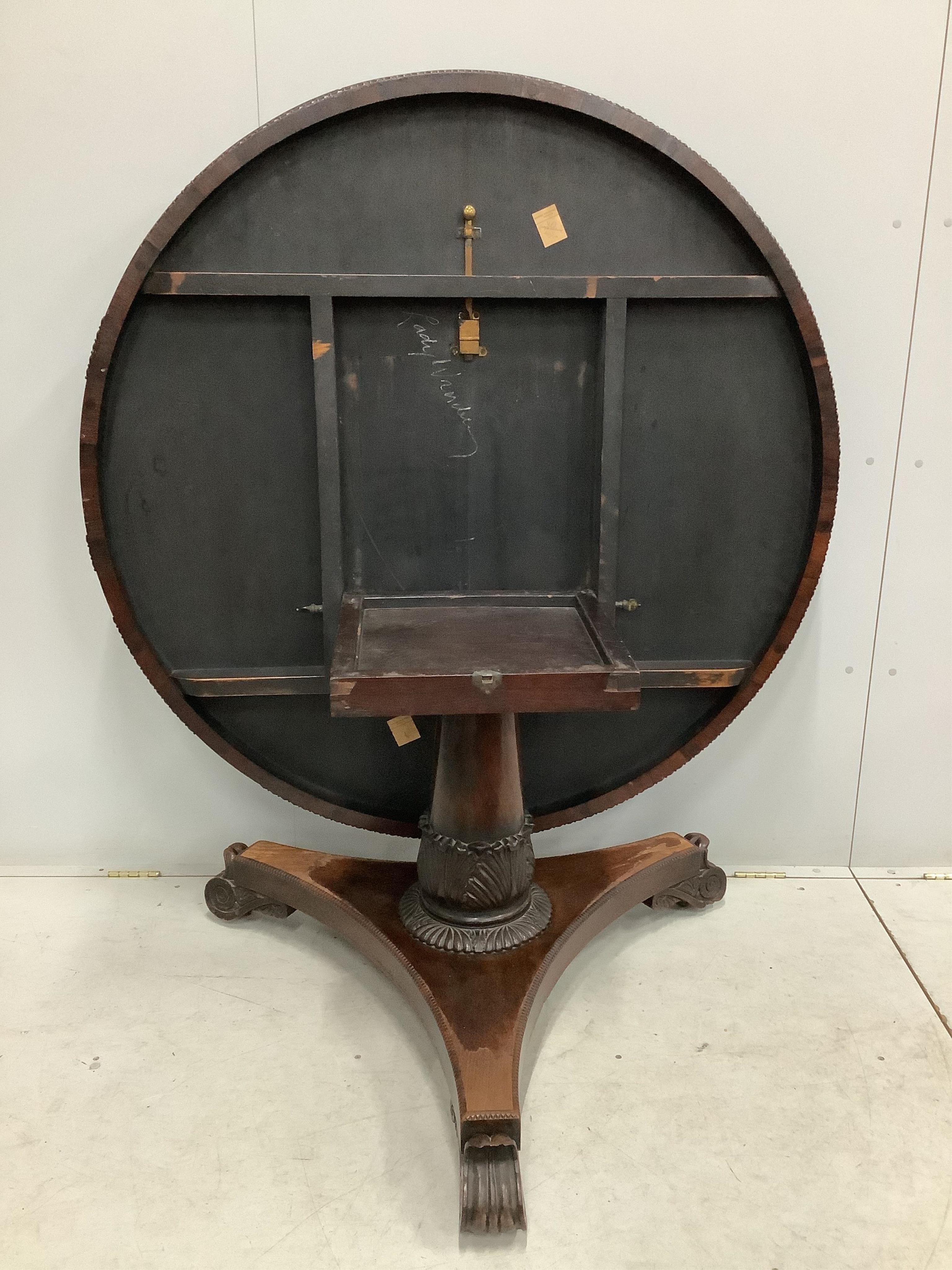 A Victorian rosewood circular tilt top breakfast table, diameter 135cm, height 72cm. Condition - poor to fair, triangular plinth base has lost approximately 10% of veneer